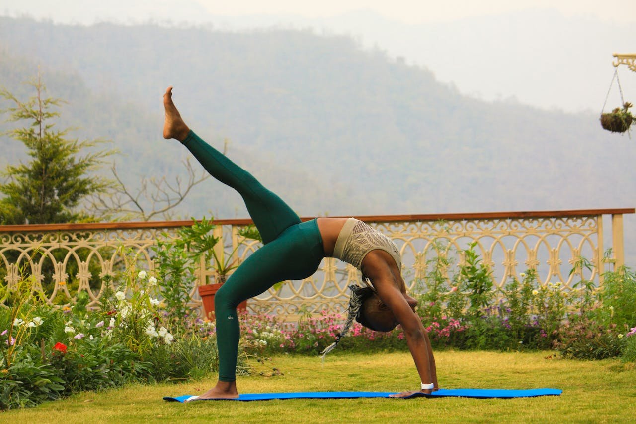 project-01-a A woman practices yoga outdoors with a scenic mountain backdrop in Rishikesh, India.