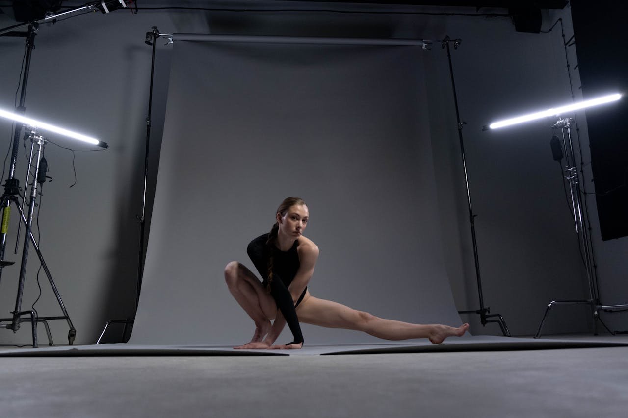 project-01-c A woman in sportswear demonstrates a yoga pose with flexibility and balance in a professional studio setting.